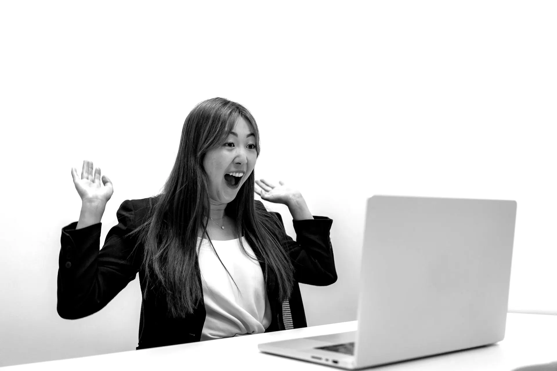 a woman sitting in front of a laptop computer