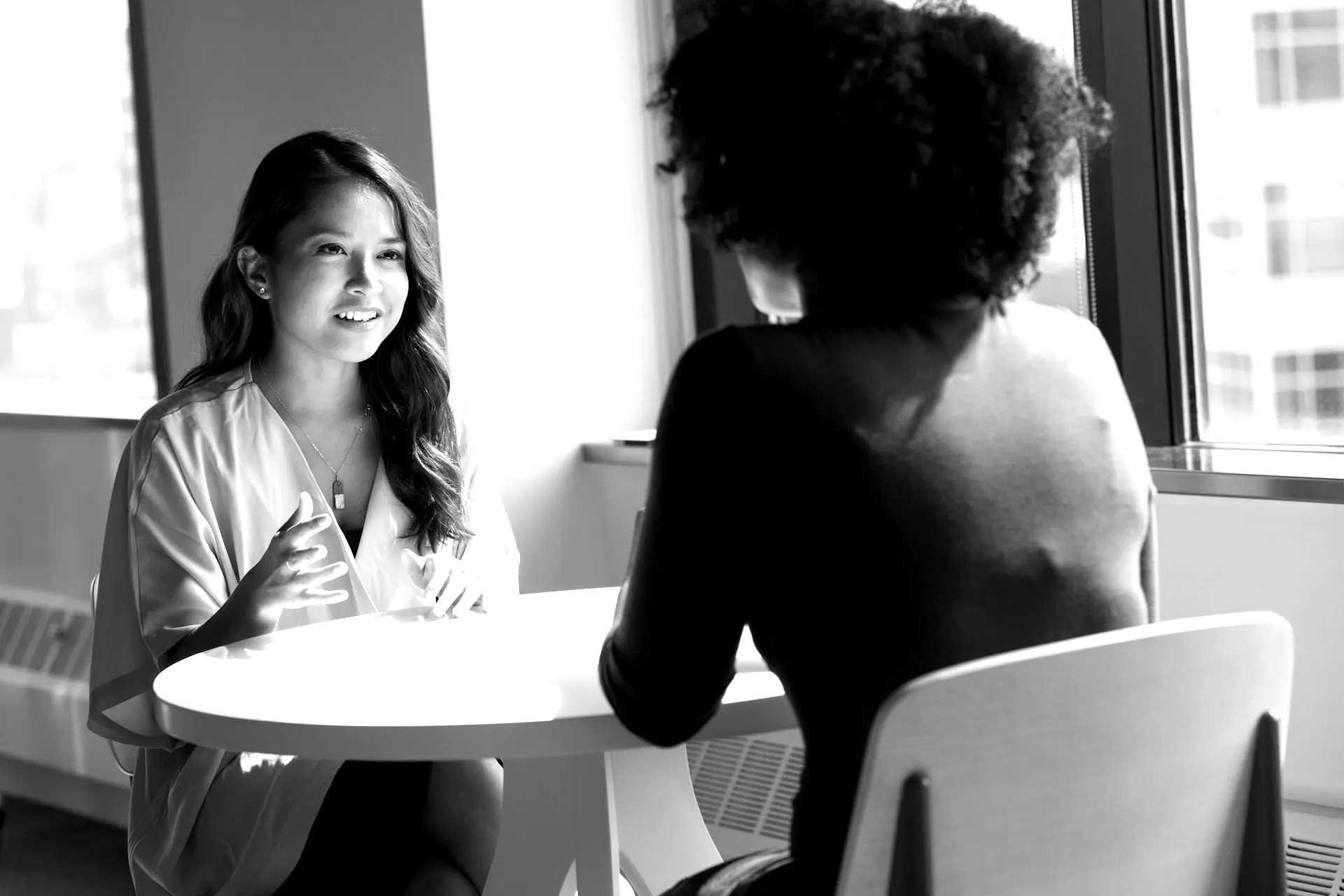 two women sitting on chair